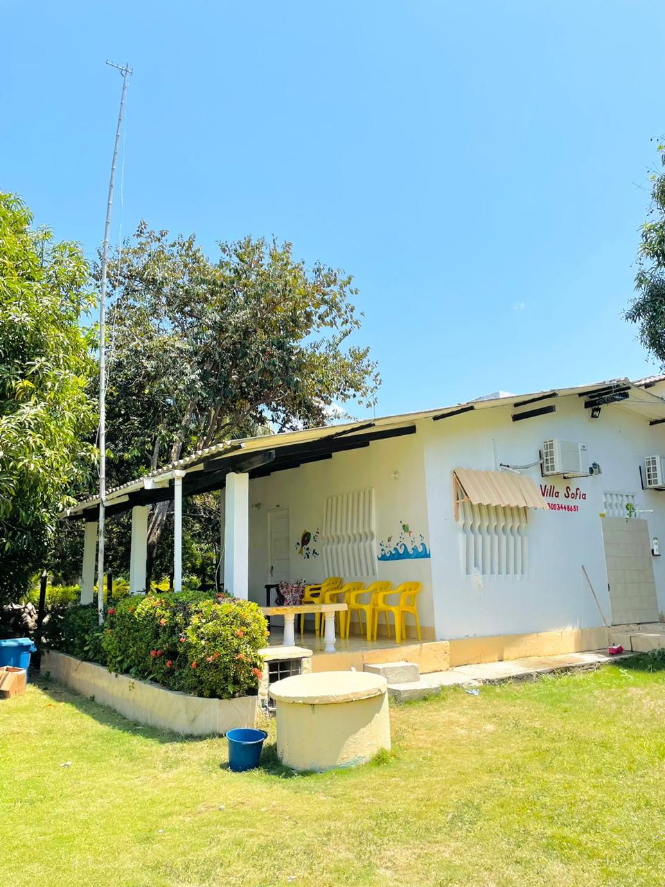 Exterior de la cabaña con jardín y aviso Villa Sofía