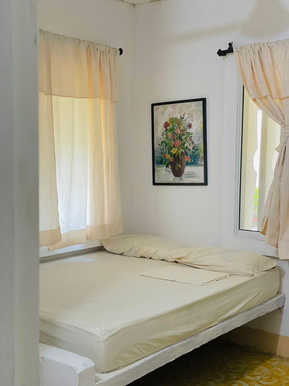 Habitación con cama doble y cortinas claras